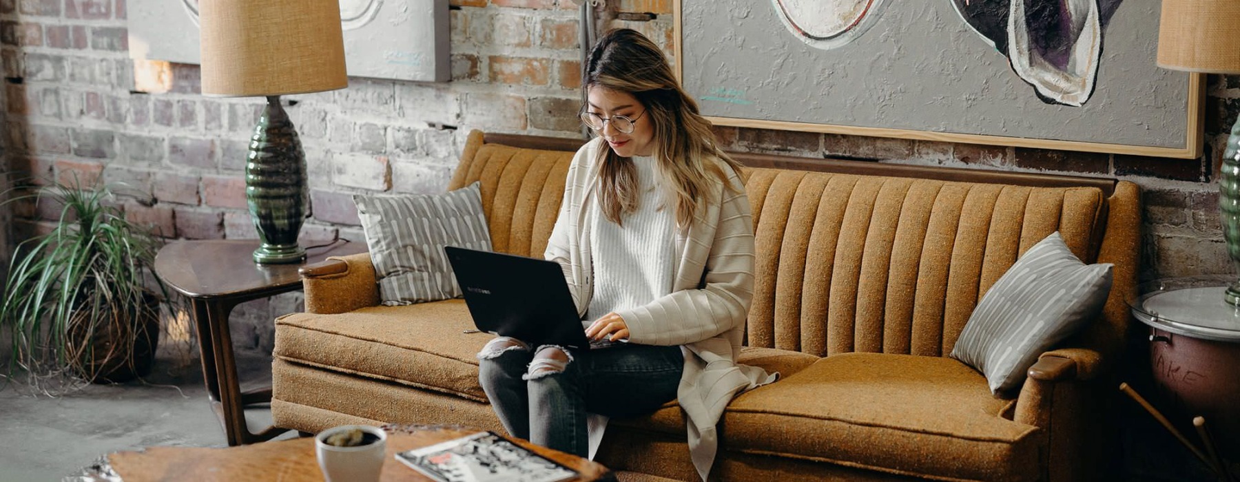 woman sitting on a couch with a laptop